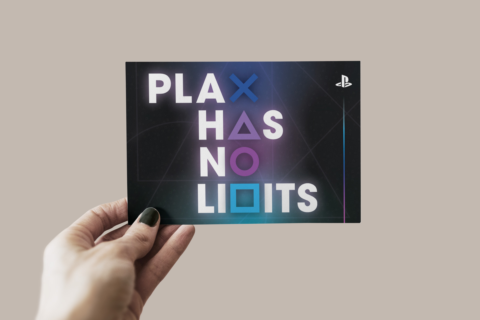 A postcard for PlayStation that features the 4 brand icons (triangle, circle, x, and square) substituting letters in the slogan "Play Has No Limits", and the PlayStation logo on a blue/purple/pink gradient background. Postcard is being held by a white hand  with nails painted black.