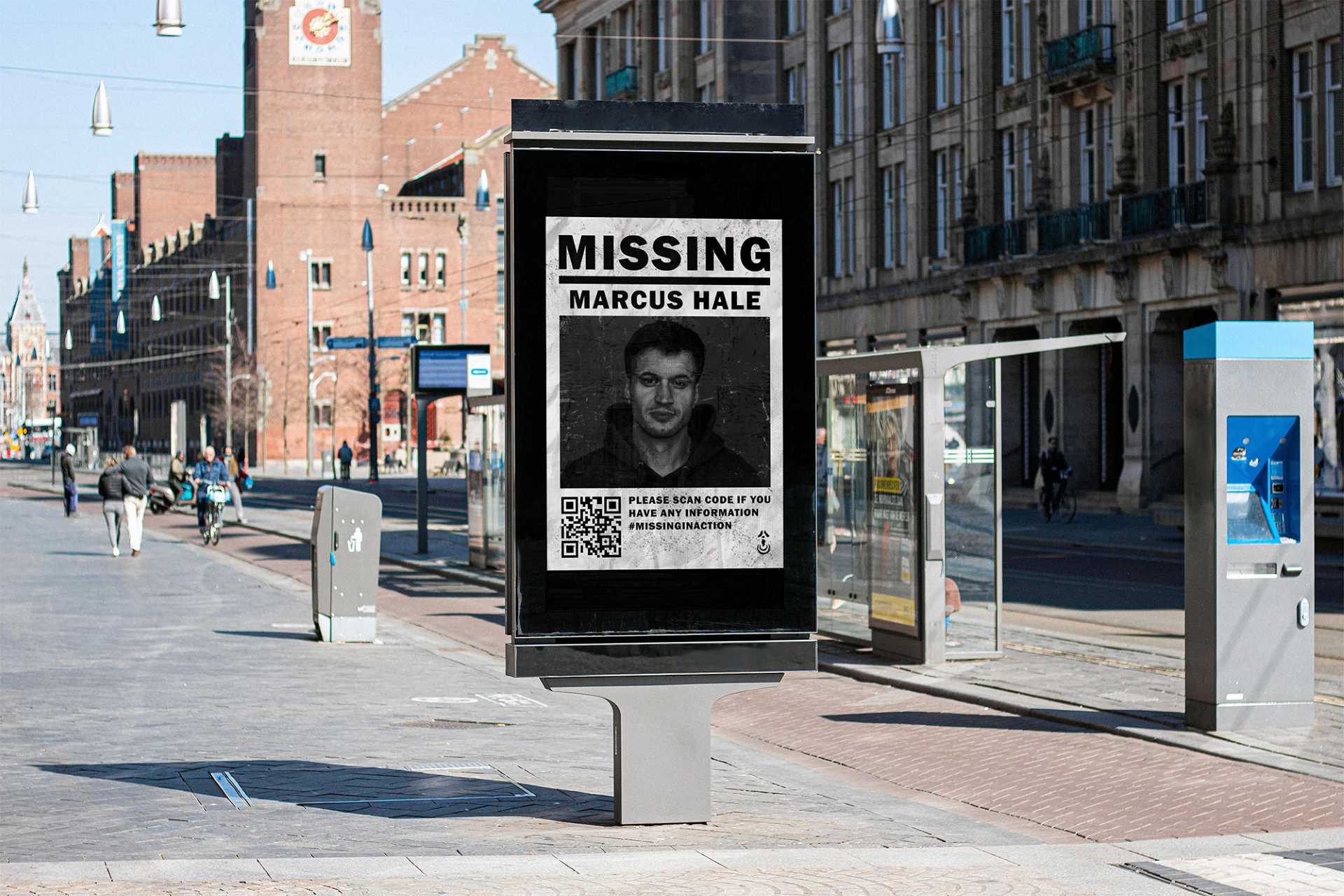 Mockup billboard in a city centre during day time of a portrait poster that reads "Missing", followed by the image of a short haired man, followed by the name "Marcus Hale", and smaller information relating to his disappearance.